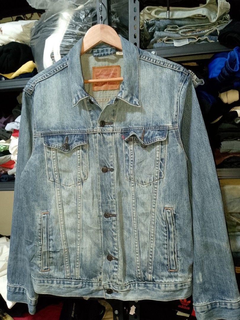 Levi's denim jacket light wash size S (Category: Coats, Jackets and Outerwear) located in Manila. Submitted by mjthrifted_second (Listing ID 1465021308, Image 1). Description: - Brand: Levi's - Wash: Light wash with natural fading - Size: Small (Relaxed fit) -Dimes: 22/26 - Features: Classic button-up front, chest flap pockets, side welt pockets, and back leather brand patch - Condition: Pre-loved with natural fading - Style: Versatile layering p