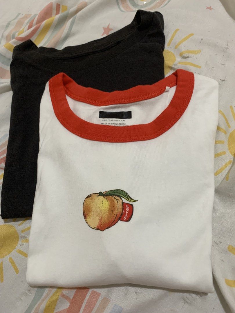 Levi's Graphic Mini Ringer T-Shirt Peach (Category: Shirts) located in San Mateo. Submitted by trendsph_956 (Listing ID 1465095893, Image 2). Description: - Brand: Levi's - Style: Graphic mini ringer tee with cropped fit - Color: Bright white with red contrast trim - Design: Cute chest graphic with iconic red tab detail - Material: Soft and comfortable cotton - Condition: Clean, well-kept, and ready to wear.