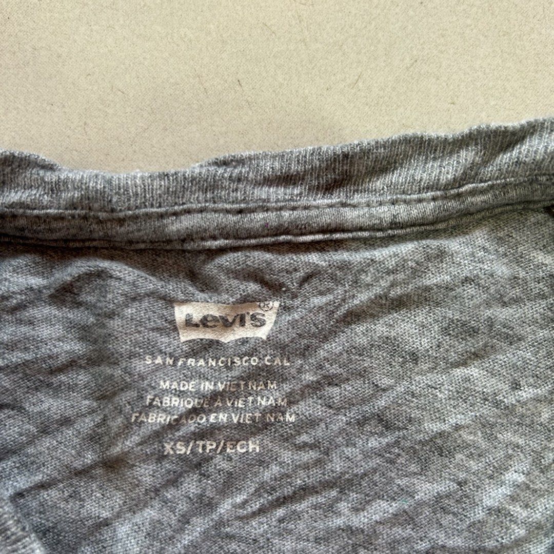 Levi's Grey Graphic T-Shirt 🥰 (Category: Shirts) located in Jinoba-an. Submitted by eegiboy (Listing ID 1465002232, Image 2). Description: - Brand: Levi's - Color: Grey with colorful palm tree graphic logo - Size: XS -small - Material: Comfortable cotton blend - Origin: Made in Vietnam - Features: Classic crew neck, short sleeves, and signature red tab on bottom hem - Condition: Great for casual everyday wear excellent condition 400plussf Dm me 