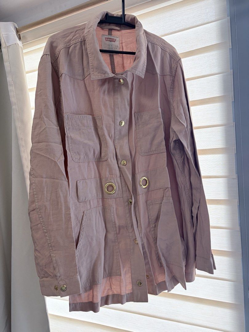 Levi's Pink Utility Jacket Size L (Category: Coats, Jackets and Outerwear) located in Manila. Submitted by cheska.closet18 (Listing ID 1465023056, Image 1). Description: - Brand/Model: Levi's Utility Jacket - Color: Pink - Size: L - Material: Lightweight, perfect for breezy days - Features: Multiple front pockets, button-down closure, metallic grommet details near the waist, collared neckline, and long sleeves with button cuffs - Condition: Excel