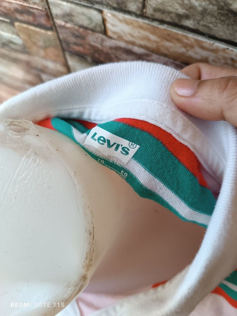 Levi's Striped Polo Shirt (Category: Babies & Kids Fashion) located in Gapan. Submitted by thrift2heaven (Listing ID 1465097845, Image 3). Description: - Brand: Levi's - Style: Short-sleeve polo shirt - Color/Pattern: Pink with red and green horizontal stripes - Details: White collar with button placket, embroidered Levi's script logo on chest, and classic red tab on side seam - Size: Large - Material: Soft and comfortable cotton - Condition: Vib