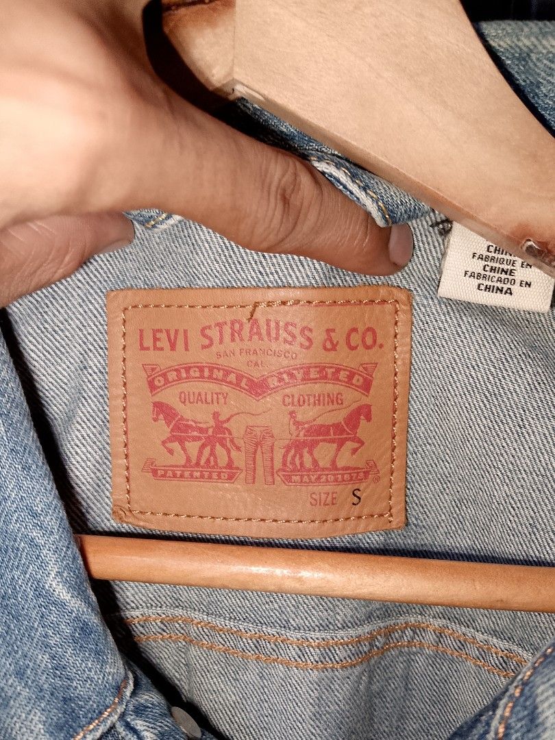 Levi's Trucker Denim Jacket Light Wash Size S (Category: Coats, Jackets and Outerwear) located in Manila. Submitted by mjthrifted_second (Listing ID 1465021880, Image 3). Description: - Brand: Levi's - Style: Classic denim jacket with traditional button-up front - Color: Light wash blue - Size: Small (Regular fit) -Dimes: 20/25 - Features: Dual chest flap pockets, side welt pockets, iconic leather patch, and red tab - Condition: Excellent, versat