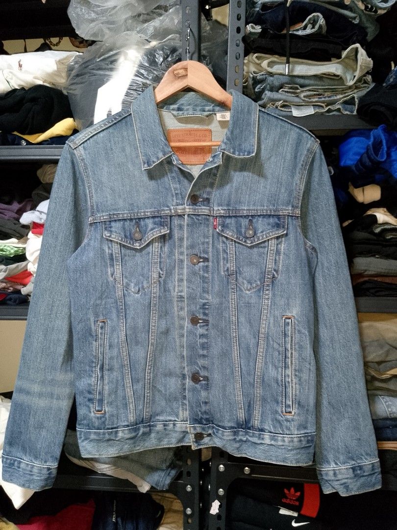 Levi's Trucker Denim Jacket Light Wash Size S (Category: Coats, Jackets and Outerwear) located in Manila. Submitted by mjthrifted_second (Listing ID 1465021880, Image 1). Description: - Brand: Levi's - Style: Classic denim jacket with traditional button-up front - Color: Light wash blue - Size: Small (Regular fit) -Dimes: 20/25 - Features: Dual chest flap pockets, side welt pockets, iconic leather patch, and red tab - Condition: Excellent, versat