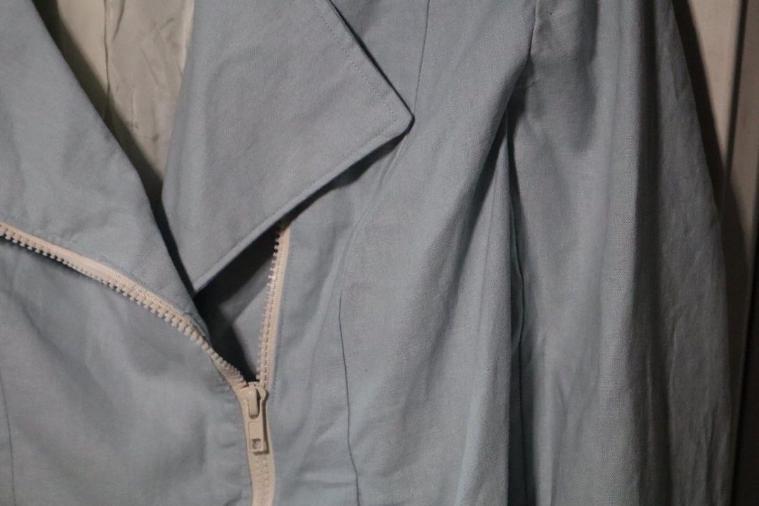 Light blue biker jacket with asymmetric zipper (Category: Coats, Jackets and Outerwear) located in Manila. Submitted by leivic (Listing ID 1465062499, Image 3). Description: - Color: Pastel blue with white lining - Style: Moto jacket, cropped length - Details: Asymmetric white front zipper, wide lapel collar, structured back paneling - Fabric: Clean finish, lightweight for breezy days - Condition: Excellent.