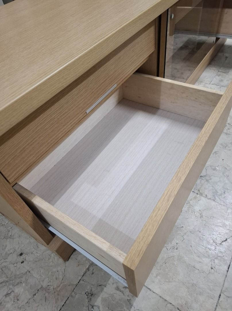 Light Oak TV Console Media Cabinet with Drawers (Category: TV Consoles) located in Quezon City. Submitted by japandemanila (Listing ID 1465005082, Image 3). Description: - Material & Finish: Wooden TV console with a stylish light oak finish - Storage: Two right-side drawers, one large left-side drawer, and a central glass-paneled sliding door cabinet - Media Space: Open interior shelf perfect for game consoles or media players - Dimensions: Rough