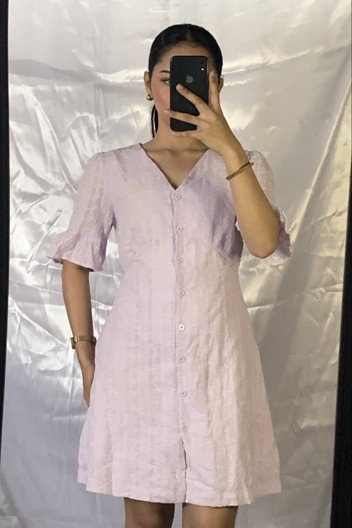 Lilac Button-Down V-Neck Dress with Ruffle Sleeves (Category: Dresses) located in Rizal. Submitted by shop_ms.lai (Listing ID 1464971486, Image 1). Description: - Color: Lilac - Style: V-neck mini dress with short ruffle sleeves - Details: Front button-down closure and textured fabric - Fit: Fitted bodice with an A-line skirt (hits above the knee) - Occasion: Perfect for casual days out and weekend brunches.