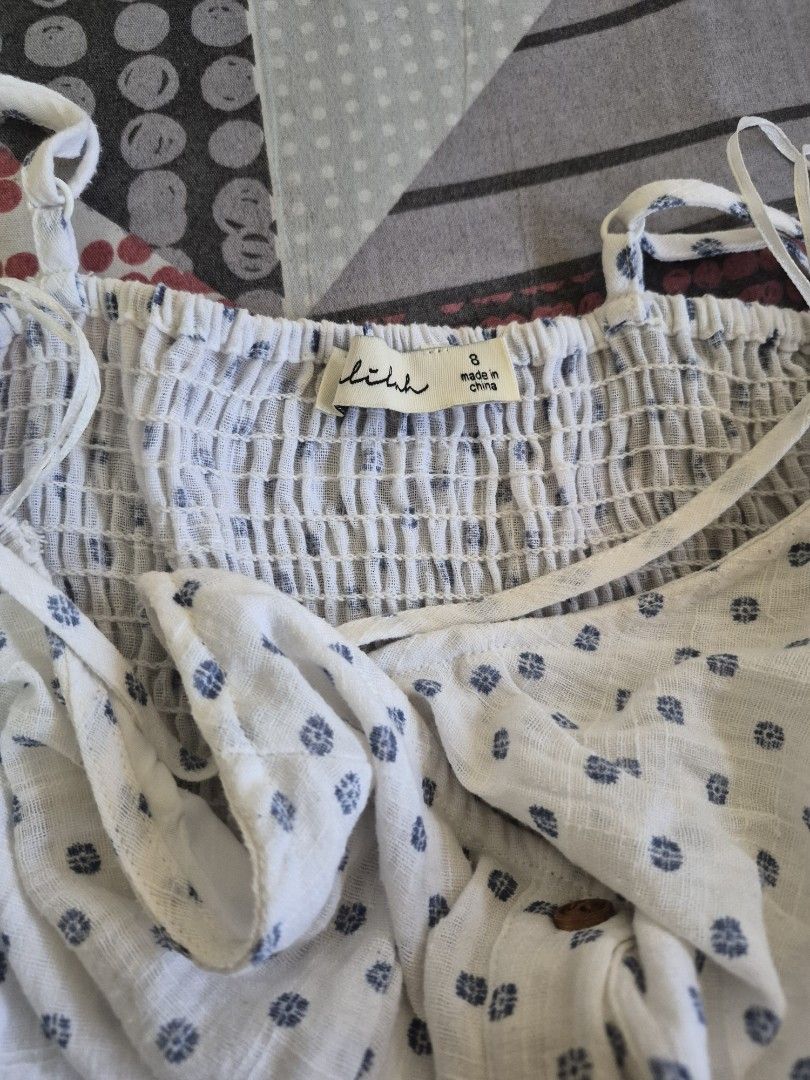 Lilah White Blue Pattern Button Down Sundress Size 8 (Category: Dresses) located in Pasig City. Submitted by ces.maranan16 (Listing ID 1465071328, Image 3). Description: - Brand/Style: Lilah sundress in white with blue patterned dots - Size: Tagged Size 8 - Design: Sleeveless with adjustable spaghetti straps - Details: Functional brown button-down front, two front pockets, and a stretchy smocked back panel for a flexible fit - Fabric: Lightweight