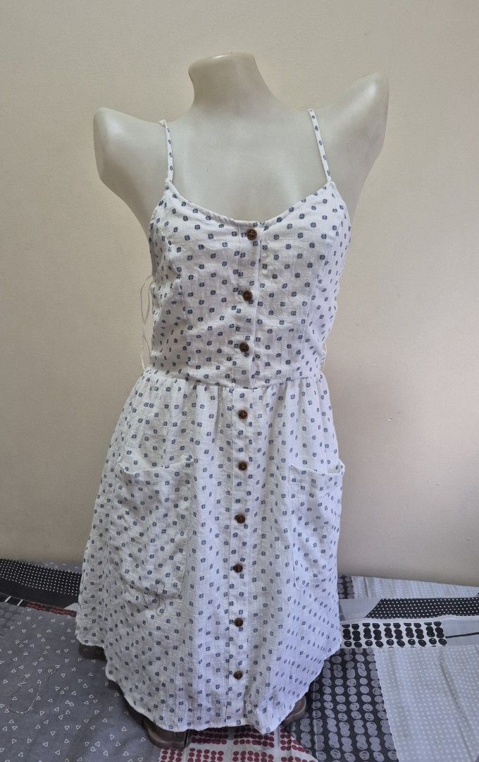 Lilah White Blue Pattern Button Down Sundress Size 8 (Category: Dresses) located in Pasig City. Submitted by ces.maranan16 (Listing ID 1465071328, Image 1). Description: - Brand/Style: Lilah sundress in white with blue patterned dots - Size: Tagged Size 8 - Design: Sleeveless with adjustable spaghetti straps - Details: Functional brown button-down front, two front pockets, and a stretchy smocked back panel for a flexible fit - Fabric: Lightweight