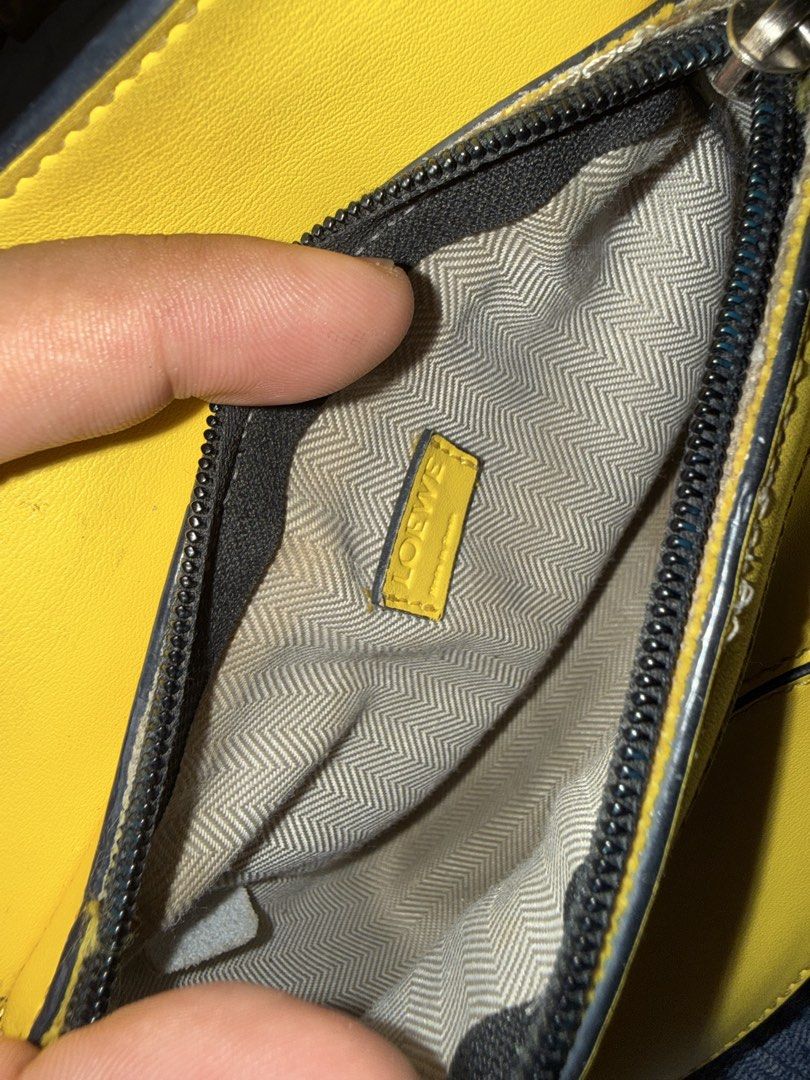 Loewe Puzzle Bag Yellow (Category: Luxury Bags & Wallets) located in Manila. Submitted by zuji.ph (Listing ID 1464998424, Image 2). Description: Bright yellow leather Loewe Puzzle bag. Distinct geometric panel design with black edge painting. Top handle configuration and structured shape. Interior lined with herringbone fabric, branded leather tag, and white origin label stamped Made in Spain. Compact shoulder or handheld style..
