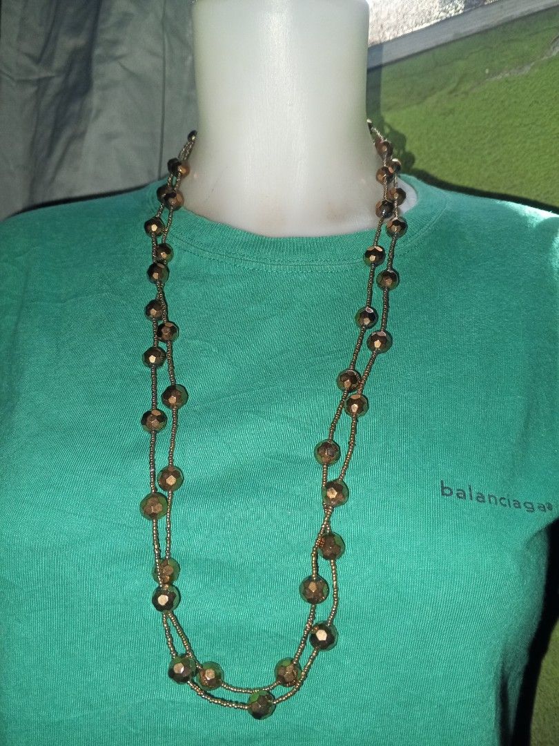 Long Beaded Statement Necklace Bronze Tone (Category: Necklaces) located in Magalang. Submitted by zeiansoria64090 (Listing ID 1464981288, Image 2). Description: - Color: Bronze-toned - Design: Features tiny seed beads and larger faceted metallic beads - Length: Extra long (can be worn single or doubled up) - Closure: Secure lobster clasp - Style Tip: Great for dressing up a simple tee or sweater.