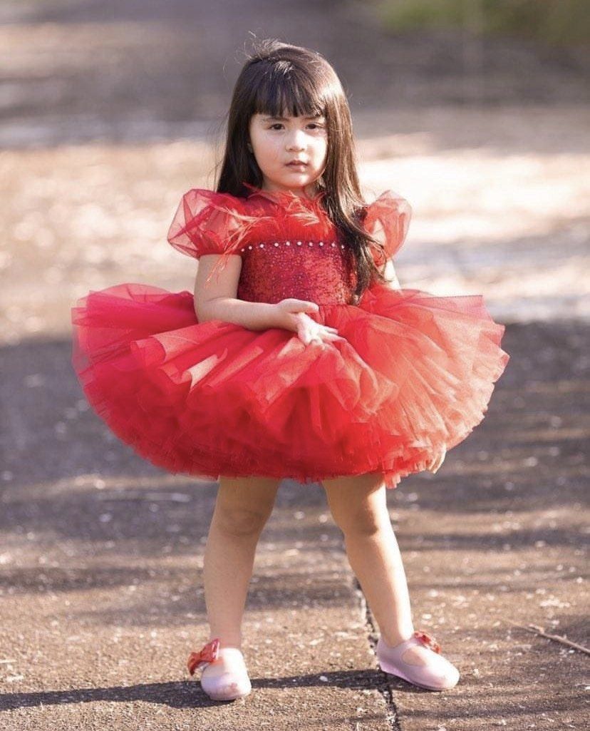 Love Sofie by Jaryk Red Tutu Dress (Category: Babies & Kids Fashion) located in Daraga. Submitted by iamsupershein (Listing ID 1465077640, Image 2). Description: - Brand: Love Sofie by Jaryk - Color: Bright red (ideal for holiday parties and special occasions) - Design: Puffy tulle skirt with a sparkling glitter bodice - Details: Feather-trimmed neckline and sheer puff sleeves - Back Feature: Large detachable sequin bow with a crystal accent - Cl