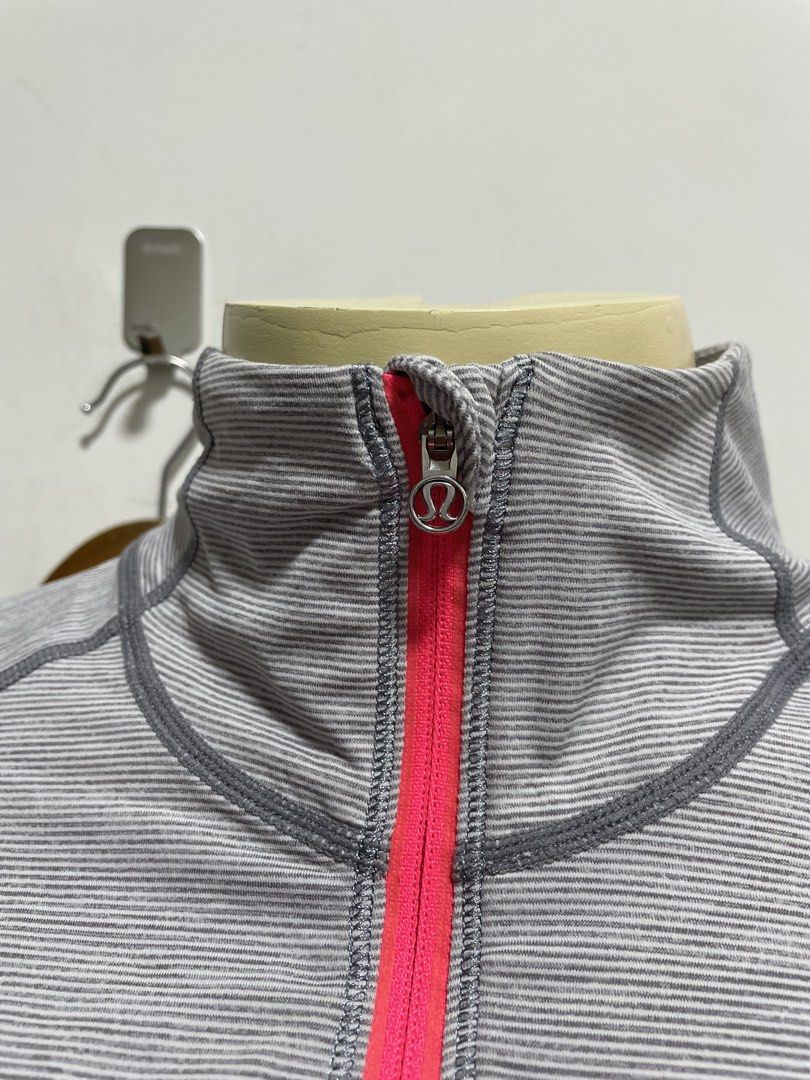 Lululemon Gray Striped Full Zip Activewear Jacket (Category: Coats, Jackets and Outerwear) located in Santiago. Submitted by UkayLuxxSelector (Listing ID 1465074493, Image 2). Description: - Authentic Lululemon activewear jacket - Color: Gray with white stripes and vibrant pink zippers - Features: High collar, secure zip pockets, and convenient thumbholes on cuffs - Breathable: Mesh panels under the arms and down the back for ventilation - Detail