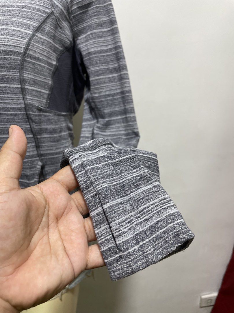 Lululemon Grey Striped Long Sleeve Half Zip Pullover (Category: Longsleeves) located in Santiago. Submitted by UkayLuxxSelector (Listing ID 1465074649, Image 2). Description: - Brand: Lululemon - Style: Grey striped long sleeve half-zip pullover - Features: High collar, thumbholes, front pockets, and side contrast panels - Details: Branded zipper pull and reflective logo near the hem .