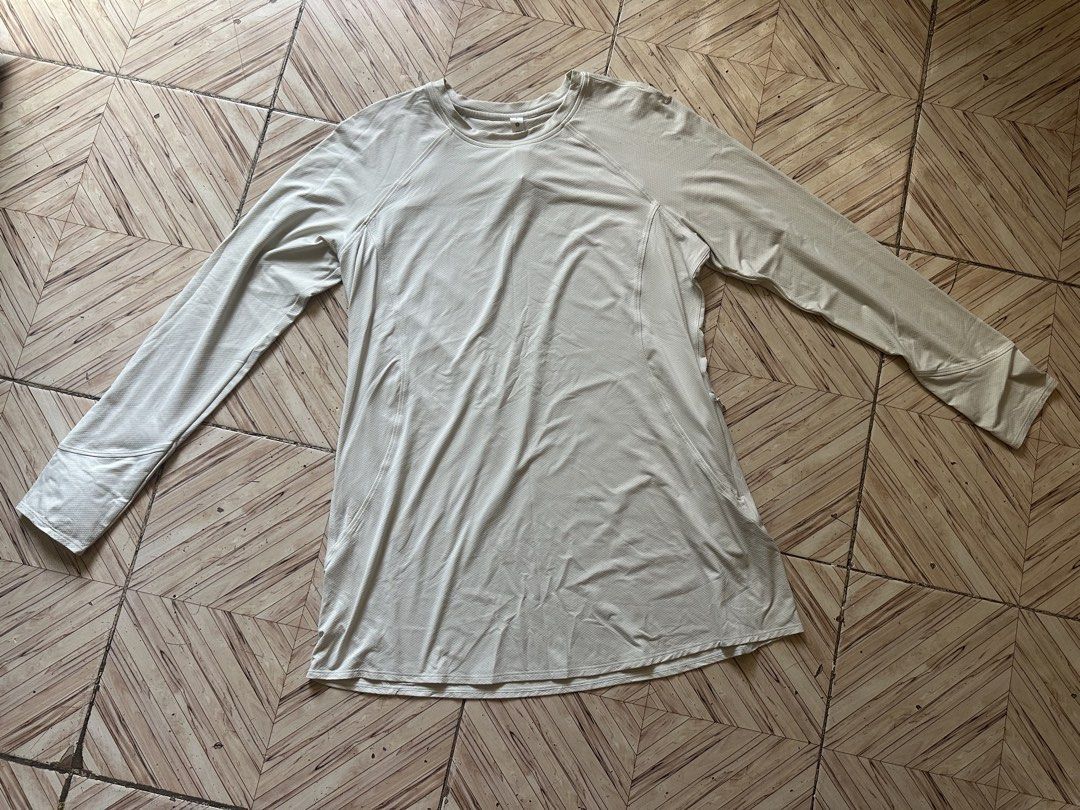 Lululemon Long Sleeve Athletic Top Size 8 (Category: Longsleeves) located in Angeles City. Submitted by alejeong27 (Listing ID 1464988331, Image 1). Description: - Brand: Lululemon - Style: Long sleeve top - Color: Off-white - Size: 8 (tag attached near collar) - Material: 88% recycled nylon, 12% elastane - Features: Breathable textured fabric, discreet zippered side pockets, and classic silver logo on the left cuff - Condition: Clean and ready t