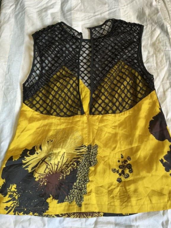 MADEINAM Preloved Mesh & Yellow Floral Statement Top (Worn Once) (Category: Others Tops) located in Manila. Submitted by ellee.stone (Listing ID 1465074987, Image 2). Description: Selling this gorgeous, hard-to-find statement piece from MADEINAM. It features a stunning, vibrant yellow abstract floral graphic print on smooth satin-feel fabric, beautifully paired with a structured black diamond-mesh fishnet yoke. The plunging V-neckline styling loo