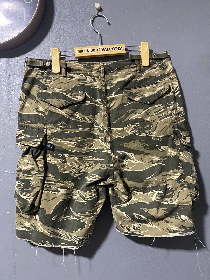 MADNESS Tiger Stripe Camo Cargo Shorts (Category: Shorts) located in Tanay. Submitted by judevalcorza (Listing ID 1465108625, Image 2). Description: - Brand: MADNESS - Small 30/32 length 19 - Design: Tiger stripe camouflage with signature brand tags - Material: Durable heavyweight cotton - Pockets: Multiple utility pockets with button flaps (sides and back) - Fit: Adjustable waist tabs on both sides for a customized fit - Details: Trendy cut-off 