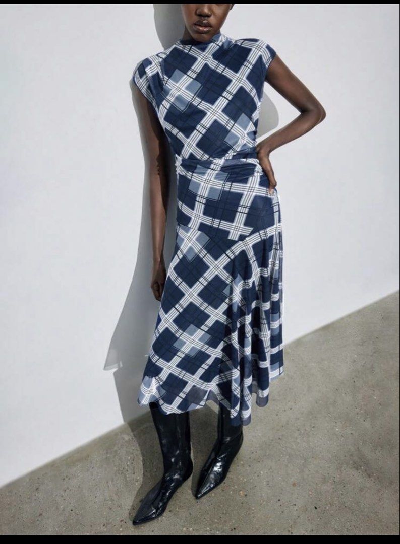 Maija Blue Plaid Midi Dress (Category: Dresses) located in Pasig City. Submitted by jnzmrq1003 (Listing ID 1464978787, Image 1). Description: - Brand/Style: Maija blue and white plaid midi dress - Neckline & Sleeves: High neckline with short cap sleeves - Fit & Silhouette: Fitted waistline with an asymmetrical draped skirt and flowing silhouette - Fabric: Lightweight material with a semi-sheer overlay - Styling Tip: Looks great paired with tall b