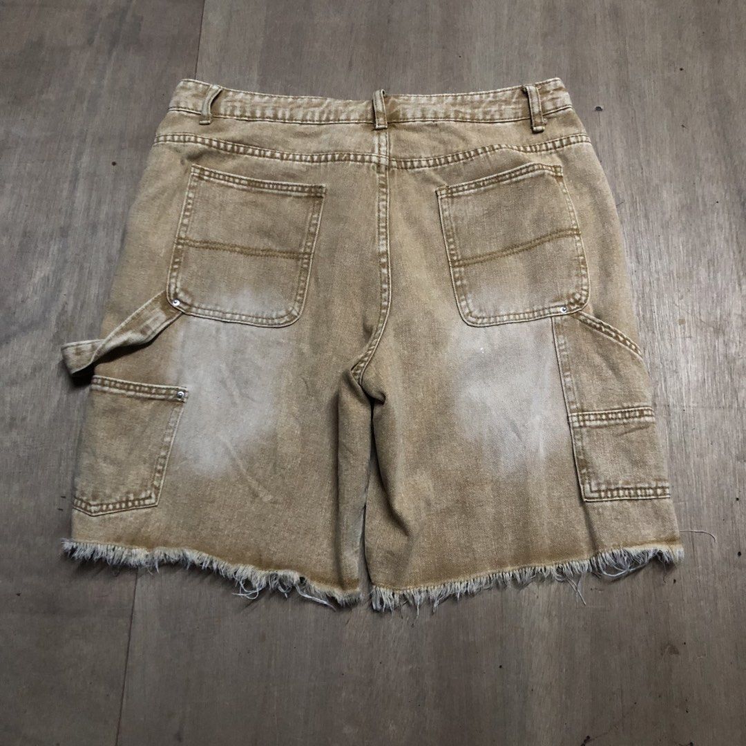 Manfinity Brown Distressed Carpenter Denim Shorts Size M (Category: Shorts) located in Dasmarinas. Submitted by johnlloydm99208 (Listing ID 1465099349, Image 2). Description: - Brand: Manfinity - Size: Medium - Color/Wash: Brown denim with acid wash finish and natural fading - Details: Front distressing, raw cut-off frayed hems, utility pockets, and hammer loop - Closure: Button fly - Style: Great streetwear piece for casual outfits.