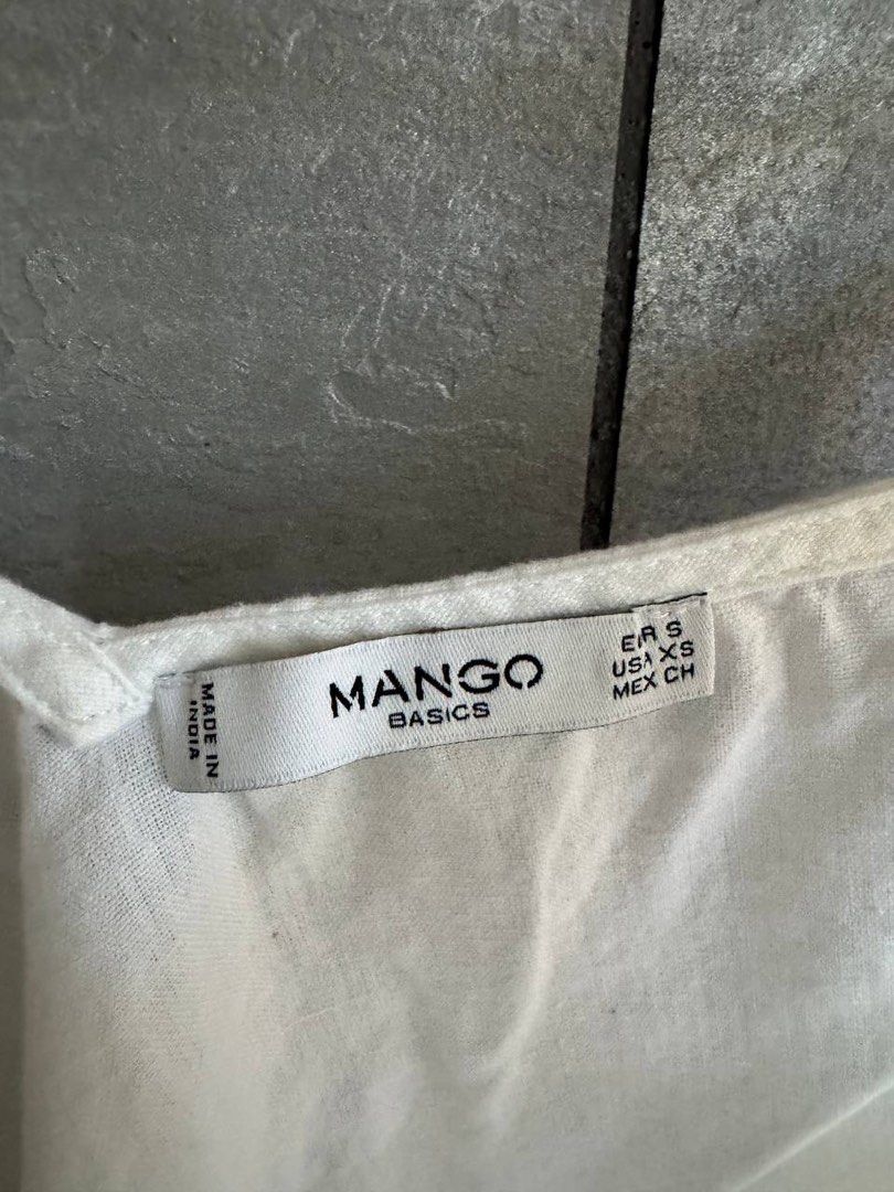 Mango Basics White Button-Front Camisole Top Size S (Category: Sleeveless) located in Taguig. Submitted by anxmz (Listing ID 1465043923, Image 2). Description: - Brand: Mango Basics - Color: White with dark brown buttons - Size: EUR S, USA XS - Features: Button-front design, adjustable tie straps - Material: Lightweight fabric, ideal for warm weather - Condition: Clean and ready to wear.