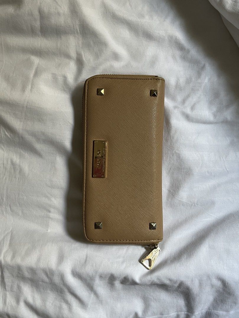 Mango Long Wallet Brown (Category: Wallets & Card holders) located in Manila. Submitted by tidymarket (Listing ID 1464993801, Image 1). Description: - Brand/Style: Mango camel long wallet - Material & Hardware: Textured saffiano material with chic gold-tone hardware and front stud details - Closure: Secure zip-around closure with an engraved pull tab - Interior: Clean black interior featuring multiple card slots, slip compartments, and a center z