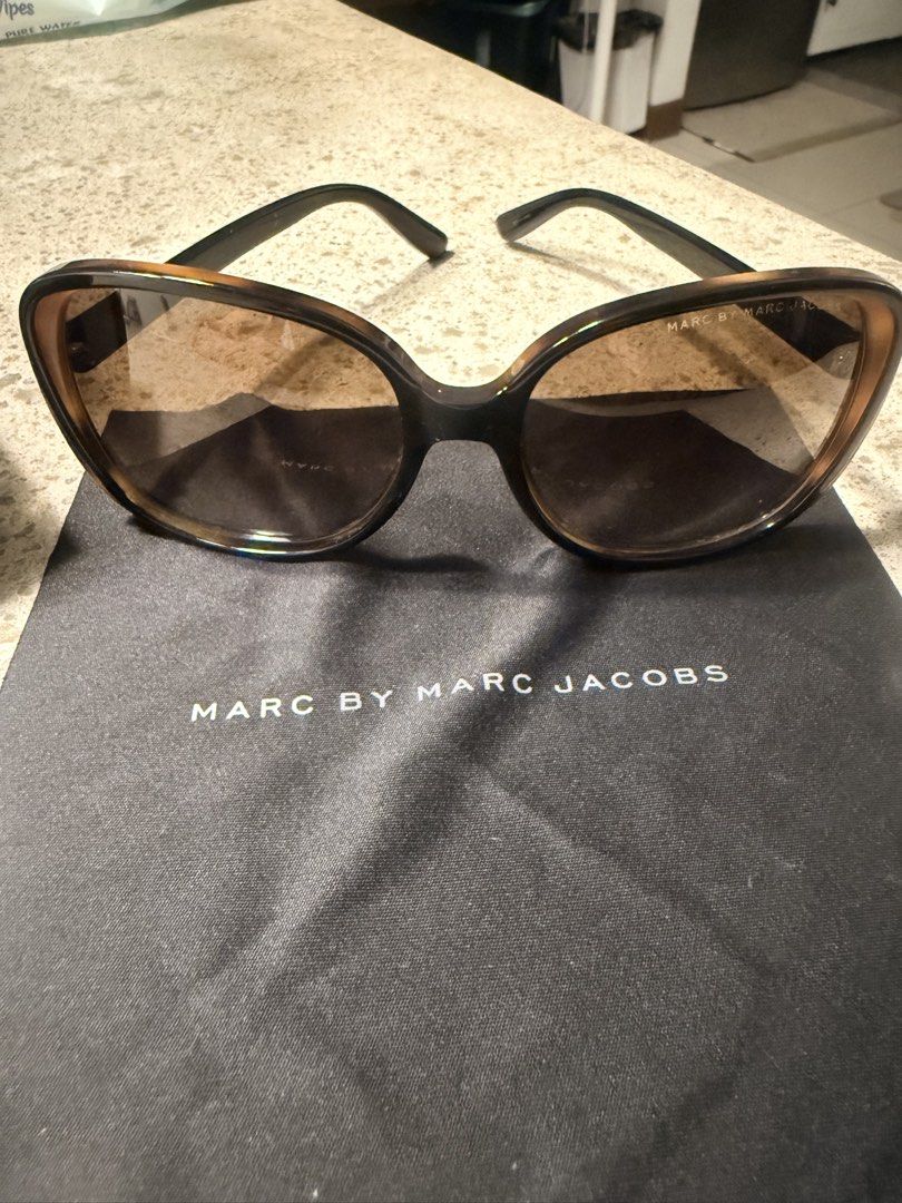 Marc by Marc Jacobs Sunglasses with Case (Category: Sunglasses & Eyewear) located in Taguig. Submitted by tipssy2 (Listing ID 1465100005, Image 2). Description: - Brand: Marc by Marc Jacobs - Style: (1) Oversized sunglasses in dark brown tortoise gradient (2) Oversized sunglasses in black - Lenses: Gradient brown for optimal sun protection - Details: Gold-tone logo plaque on temples and hexagonal hinge with engraved branding - Inclusions: Origina