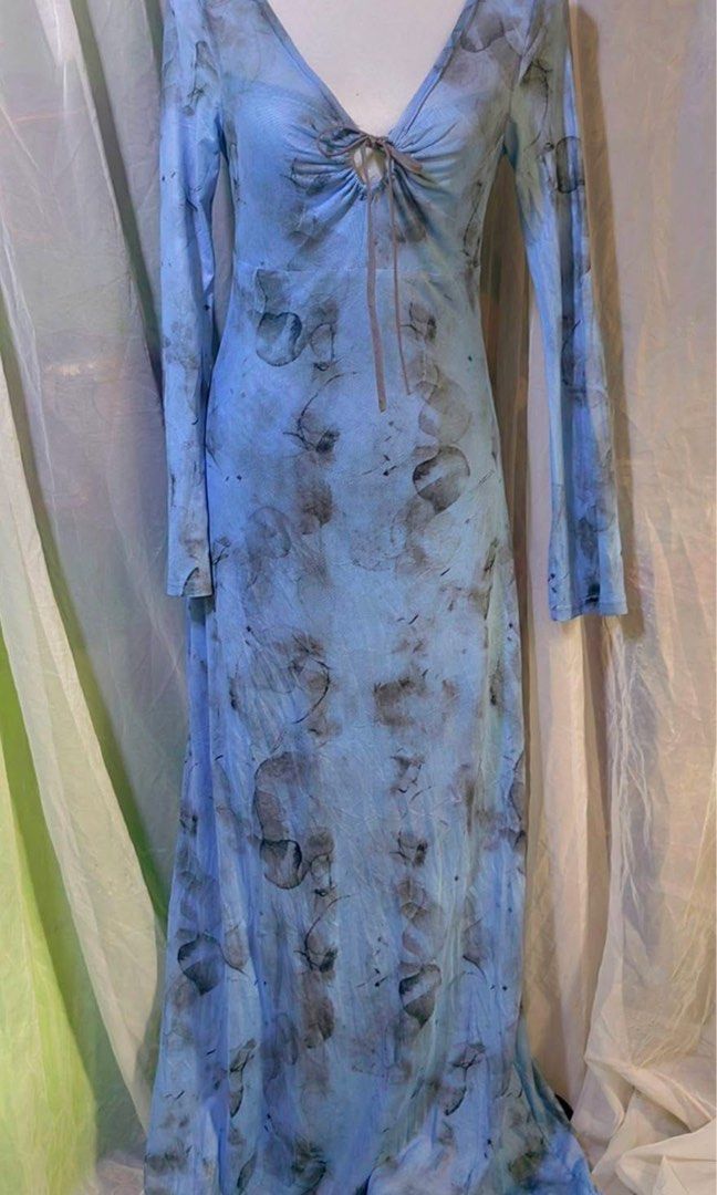 Medium Elegant Mesh Double lining Blue Maxi Dress (Category: Dresses) located in Cavite. Submitted by wishie_collects (Listing ID 1465037021, Image 2). Description: Style & Silhouette: A long, floor-length maxi dress with a slim, form-fitting silhouette and long sleeves. Design Details: It features a deep V-neckline with a small front keyhole cutout linked by a ring detail. Pattern & Color: It is made of a soft, lightweight fabric with an abstrac