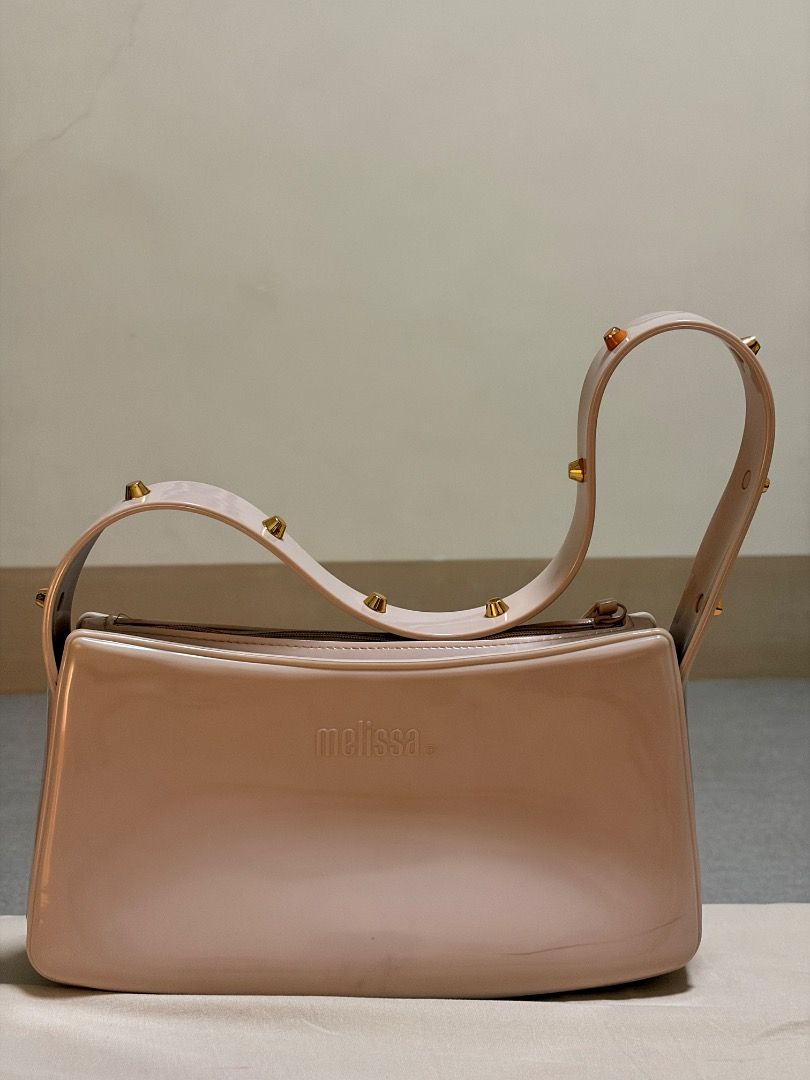 Melissa pink jelly shoulder bag with studs (Category: Shoulder Bags) located in Manila. Submitted by quekrystel35491 (Listing ID 1464987698, Image 1). Description: - Brand: Melissa - Color: Light pink - Material: Water-resistant jelly (easy to wipe clean) - Design: Structured shape, single strap with gold-toned studs, top zip closure, and embossed front logo - Size: Standard (fits daily essentials easily) - Condition: Good, with minor scuff marks