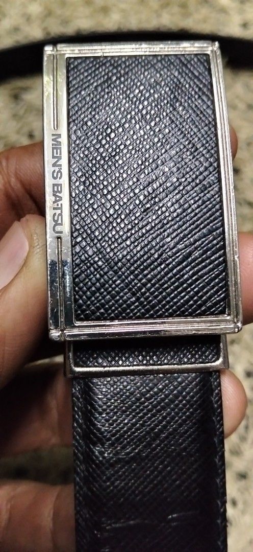 MEN'S BATSU Black Leather Belt (Category: Belts) located in Paranaque City. Submitted by michael-08 (Listing ID 1465168365, Image 2). Description: - Brand/Model: Men's Batsu - Color: Classic Black - Material & Texture: Premium leather with Saffiano texture pattern - Hardware: Silver-tone metal buckle with engraved branding - Design: Clean edges and sturdy build for long-lasting wear - Versatility: Ideal for business casual and formal outfits - Co
