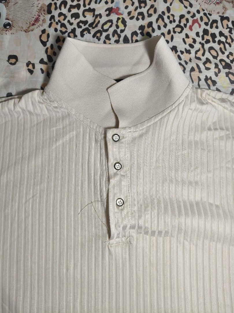 Men's Cream Short-Sleeve Ribbed Polo (Category: Tshirts & Polo Shirts ) located in Lapu Lapu. Submitted by hooman422 (Listing ID 1465072082, Image 2). Description: • Color: Cream / Off-white / Beige • Material/Texture: Vertical ribbed knit texture • Neckline: Stand collar (mandarin/band style) with a three-button placket closure • Fit/Style: Casual, modern minimal, or "old money style" aesthetic.