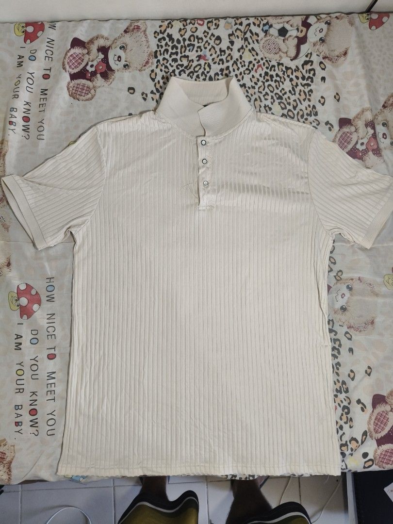 Men's Cream Short-Sleeve Ribbed Polo (Category: Tshirts & Polo Shirts ) located in Lapu Lapu. Submitted by hooman422 (Listing ID 1465072082, Image 1). Description: • Color: Cream / Off-white / Beige • Material/Texture: Vertical ribbed knit texture • Neckline: Stand collar (mandarin/band style) with a three-button placket closure • Fit/Style: Casual, modern minimal, or "old money style" aesthetic.