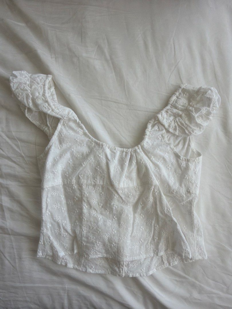MESHKI White Embroidered Lace Crop Top (Category: Sleeveless) located in Cavite. Submitted by klarev (Listing ID 1465010600, Image 2). Description: - Color: White - Size: Small - Material: Lightweight fabric with all-over eyelet embroidery - Design: Scoop neckline with string tie, front button-down closure, and short cap sleeves with ruffled hem.