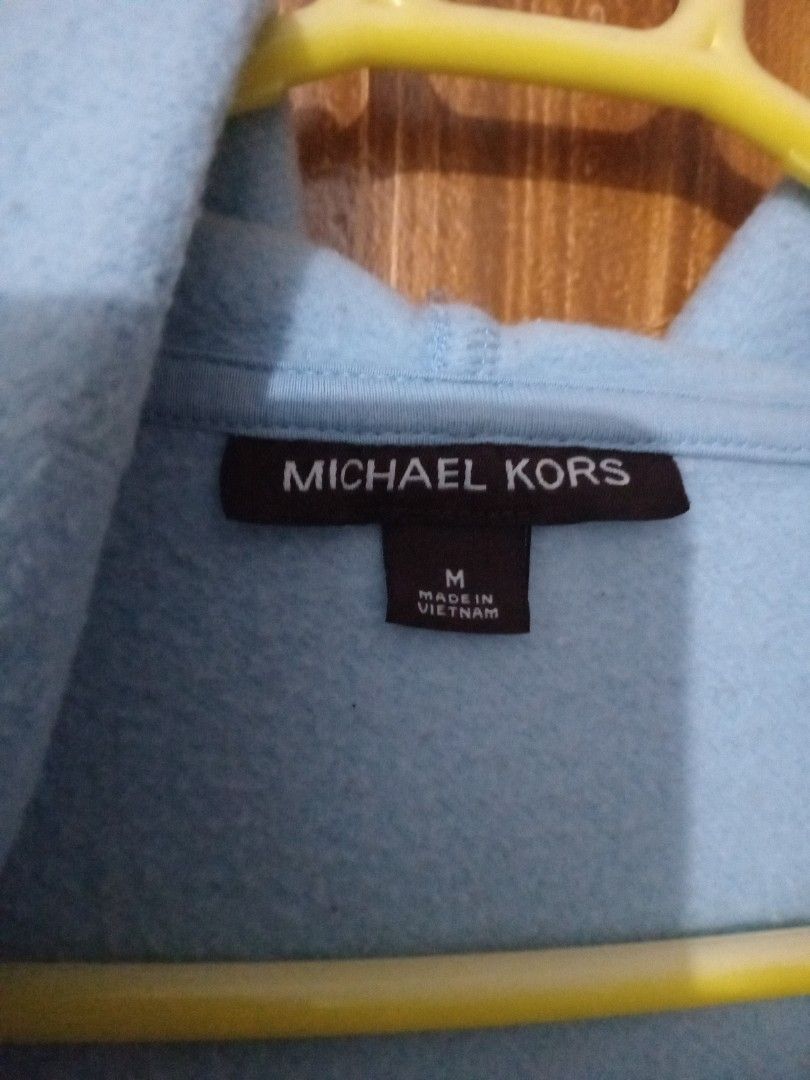 Michael Kors Light Blue Zip Hoodie (Category: Coats, Jackets and Outerwear) located in Marikina City. Submitted by joyful.finds (Listing ID 1464969451, Image 2). Description: Light blue zip-up hoodie from Michael Kors. Size medium. Soft fleece material with a front zipper and split kangaroo pockets. Hoodie attached at the neckline. Minimal branding with small embroidered letters on the chest. Ribbed cuffs and hem line. Easy to throw on for cooler