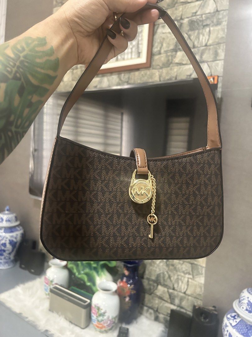 Michael Kors Lyra Brown Shoulder Bag (Category: Shoulder Bags) located in Dapitan. Submitted by loadserq (Listing ID 1464983520, Image 1). Description: - Authentic Michael Kors Lyra bag - Brown monogram canvas with tan leather strap and trim - Elegant gold-tone hardware featuring a lock charm and key chain - Pristine, clean condition inside and out - Brand new with retail tag still attached (Original Price: $398.00) -negotiable .