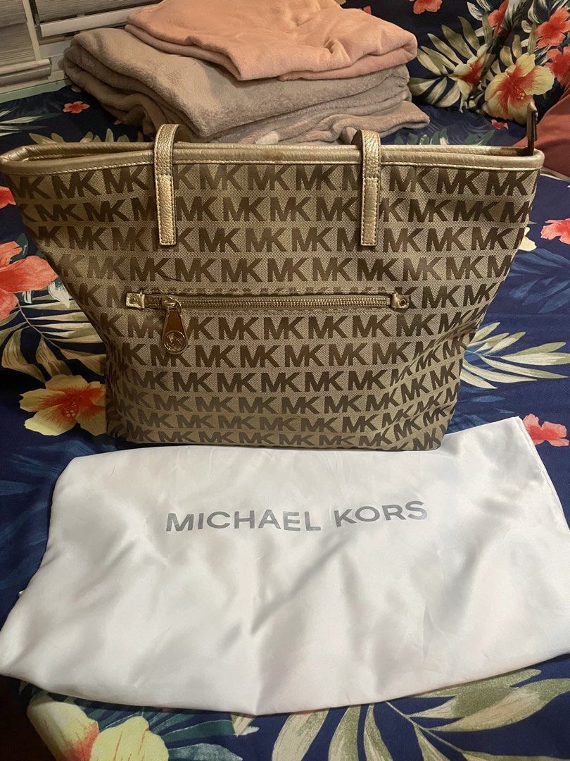 Michael Kors MK Monogram Tote Bag with Dust Bag (Category: Tote Bags) located in Badoc. Submitted by ganalgeral12718 (Listing ID 1465128590, Image 2). Description: - Brand: Michael Kors - Design: Signature MK monogram canvas with gold leather trim - Closure: Secure zip-top closure - Pockets: Outer zippered pocket, multiple interior slip pockets, and one inner zip compartment - Inclusions: Original white Michael Kors dust bag - Condition: Clean in