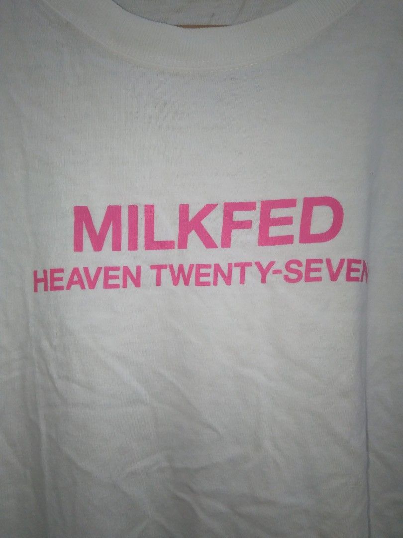 Milkfed Heaven Twenty-Seven White Graphic Tee (Category: Activewear) located in Manila. Submitted by jaradhiggins24 (Listing ID 1465114885, Image 2). Description: - Brand: Milkfed - Color: White with pink graphic lettering - Design: 'MILKFED HEAVEN TWENTY-SEVEN' on front with a woven inspirational quote patch near the hem - Fit/Style: Classic crew neck, short sleeves - Size: ONE - Material: 100% cotton (standard care instructions included) - Cond