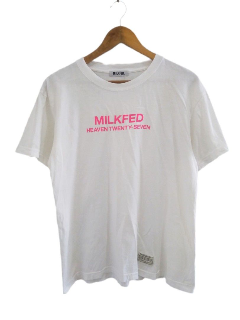 Milkfed Heaven Twenty-Seven White Graphic Tee (Category: Activewear) located in Manila. Submitted by jaradhiggins24 (Listing ID 1465114885, Image 1). Description: - Brand: Milkfed - Color: White with pink graphic lettering - Design: 'MILKFED HEAVEN TWENTY-SEVEN' on front with a woven inspirational quote patch near the hem - Fit/Style: Classic crew neck, short sleeves - Size: ONE - Material: 100% cotton (standard care instructions included) - Cond