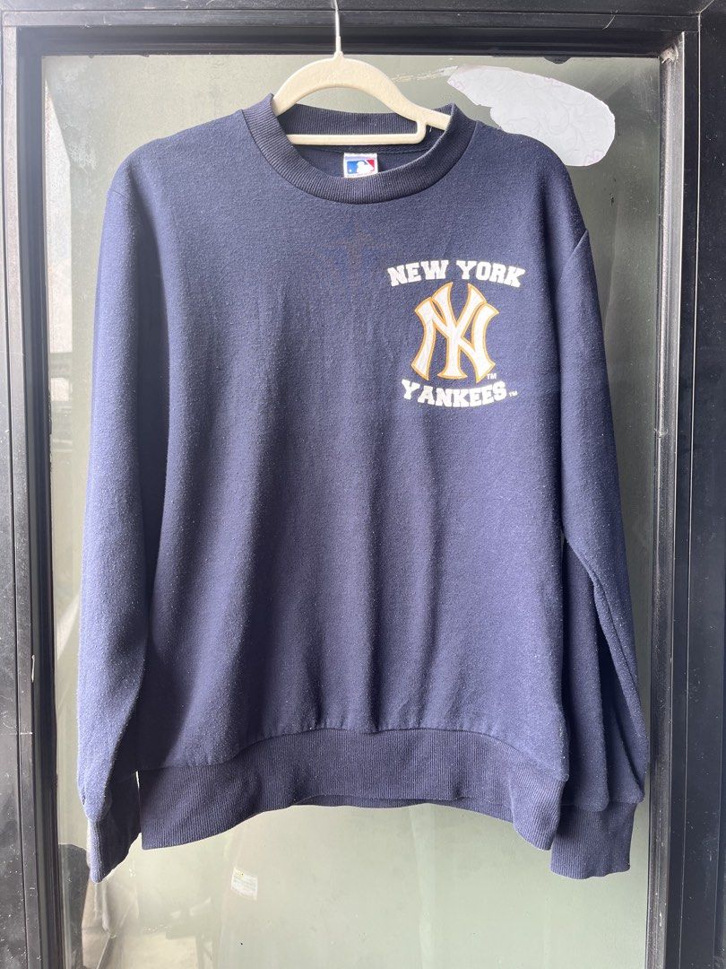 MLB New York Yankees Navy Blue Sweatshirt (Category: Coats, Jackets and Outerwear) located in Manila. Submitted by kingjamessthriftt (Listing ID 1465015663, Image 1). Description: - Official MLB New York Yankees crewneck sweatshirt - Color: Navy blue with white and gold team chest graphic - Material: Comfortable standard fit cotton blend - Details: Long sleeves, ribbed cuffs and hem - Authenticity: Features official Major League Baseball neck tag