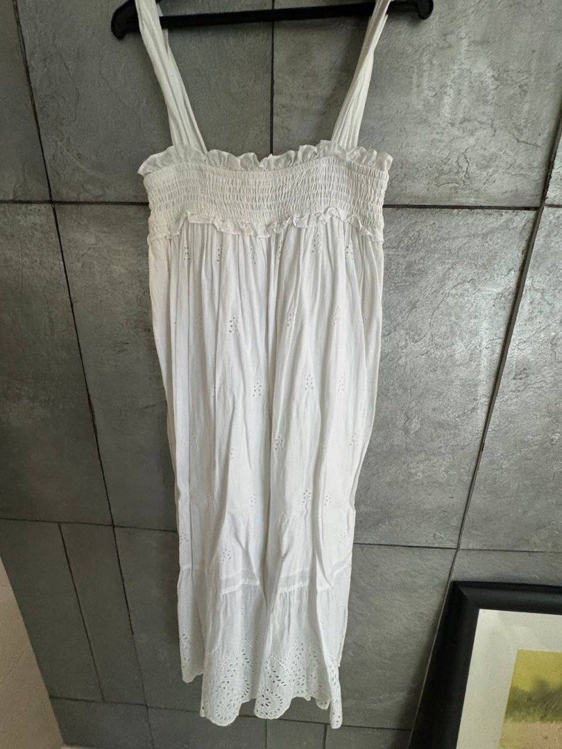 MNG White Smocked Eyelet Top XS (Category: Blouses) located in Taguig. Submitted by anxmz (Listing ID 1465043737, Image 1). Description: - Brand: MNG - Size: XS (EUR XS, USA 2) - Material: Lightweight cotton - Design: Smocked bodice with ruffle trim and eyelet embroidery - Flaw: Noticeable yellow stain on the ruffled edge near the smocked section.