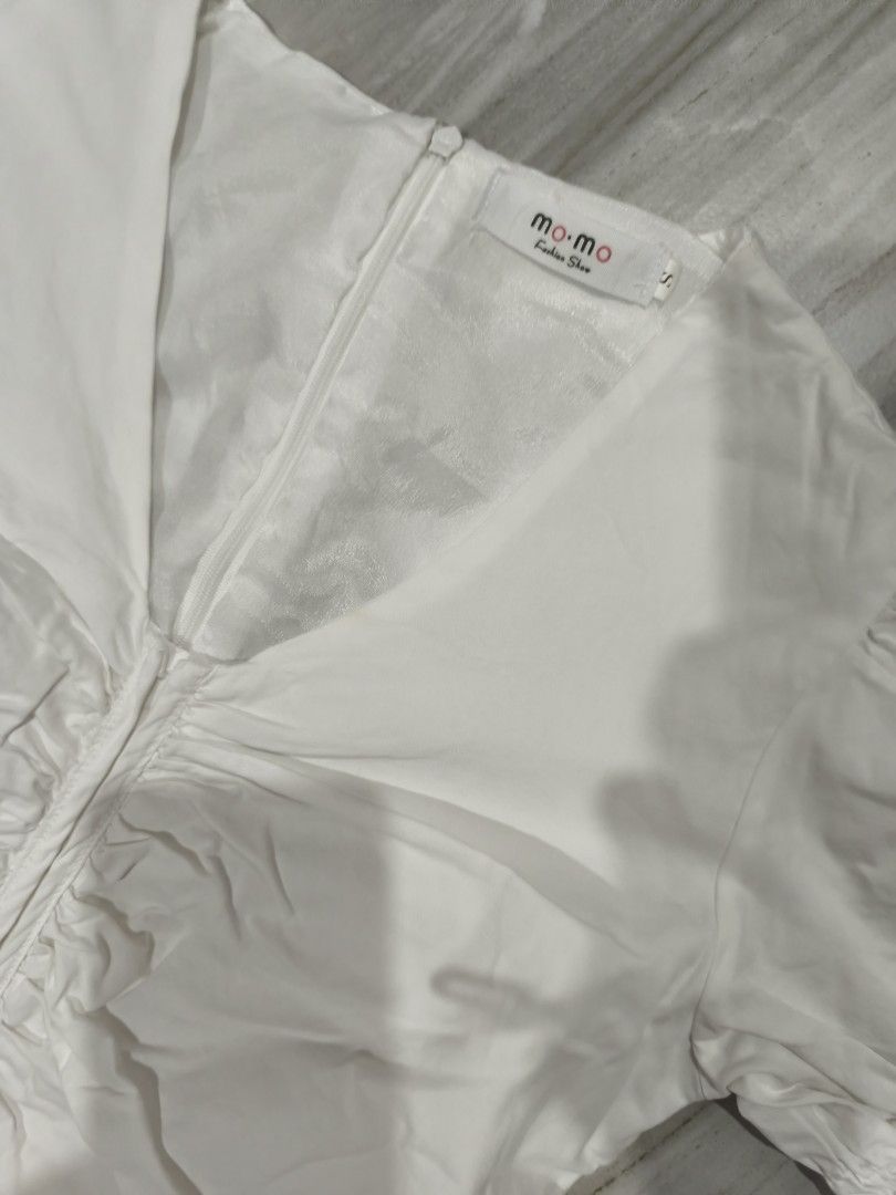 Mo Mo White Ruched Midi Dress Size S (Category: Dresses) located in Manila. Submitted by pearlichelle (Listing ID 1464997636, Image 3). Description: - Brand: Mo Mo Fashion Show - Size: S (Brand new with tag attached) - Color: White - Design: V-neckline, puff sleeves, ruched front, and back zipper closure - Flaw: Small yellowish stain on the right side near the waist area.