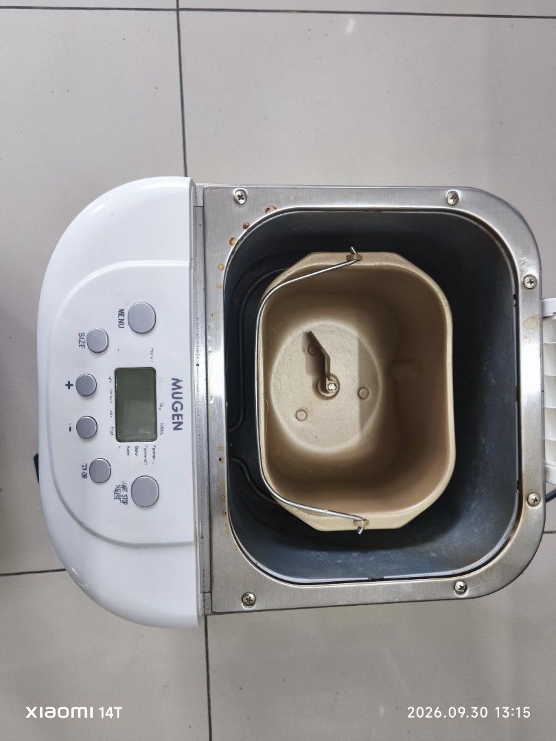 Mugen Automatic Bread Maker Machine (Category: Breadmakers) located in Shah Alam. Submitted by zaharein (Listing ID 1465008449, Image 3). Description: - Brand: Mugen XBM-6000 1kg Automatic Bread Maker - Design: Stainless steel body with a white top lid and digital control panel - Versatile Functions: Multiple menu options including basic bread, cake, dough, jam, and yogurt - Included Accessories: Non-stick baking pan and kneading paddle - Power: 