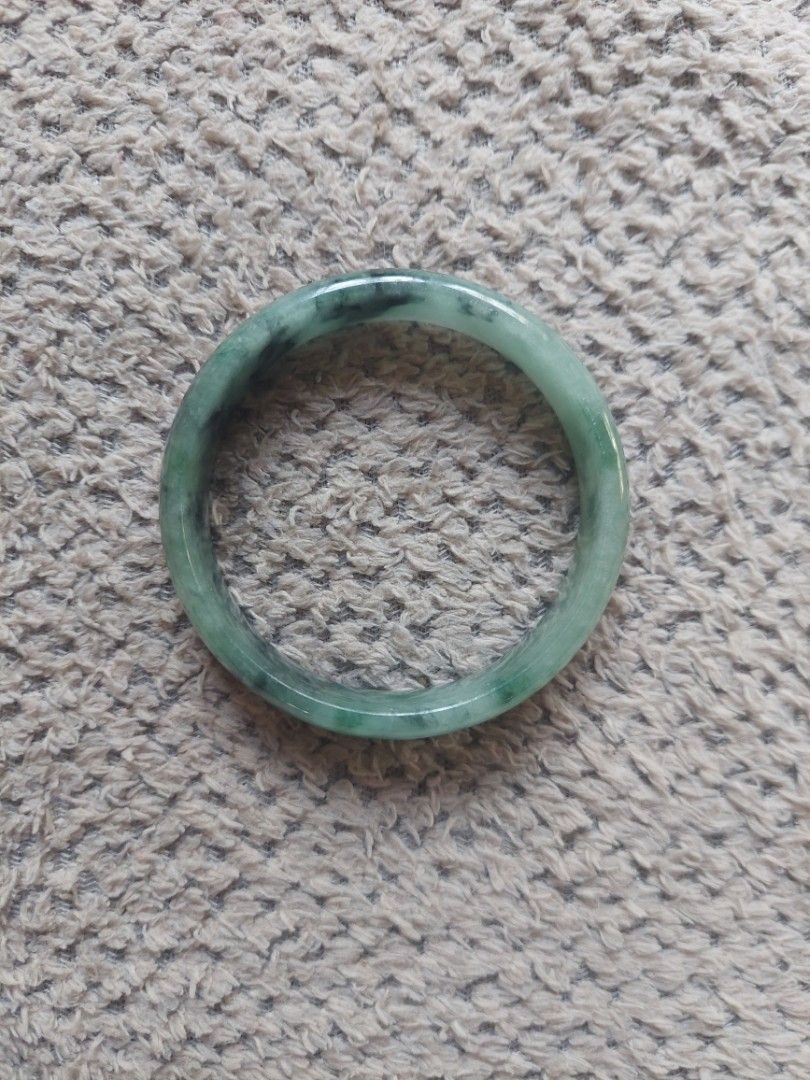 Natural green jadeite stone bangle bracelet (Category: Bracelets) located in Bulacan. Submitted by evangelion346 (Listing ID 1465047730, Image 1). Description: - Genuine green jade bangle with deep forest green patches and natural dark inclusions - Smooth, polished surface all around for a comfortable wear - Rounded profile with a comfortable inner diameter - Features unique natural stone variations throughout the piece - Versatile and classic ac