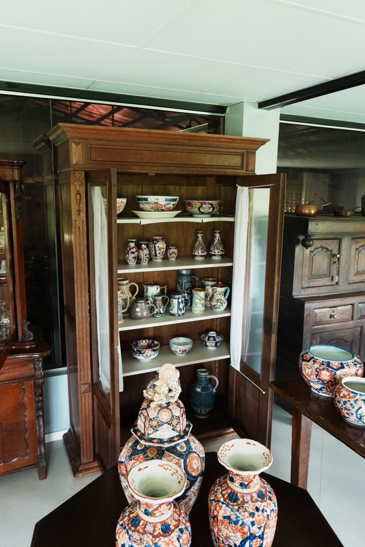 Neoclassical-Style Glazed Display Cabinet (Category: Vintage Collectibles) located in Manila. Submitted by heleensym (Listing ID 1464970559, Image 3). Description: An elegant wooden cabinet featuring two glazed doors, panelled lower sections, and a substantial moulded cornice. Fluted uprights and carved pendant details frame the doors, while a warm wood finish gives the piece an understated character. Four internal shelves provide generous displa