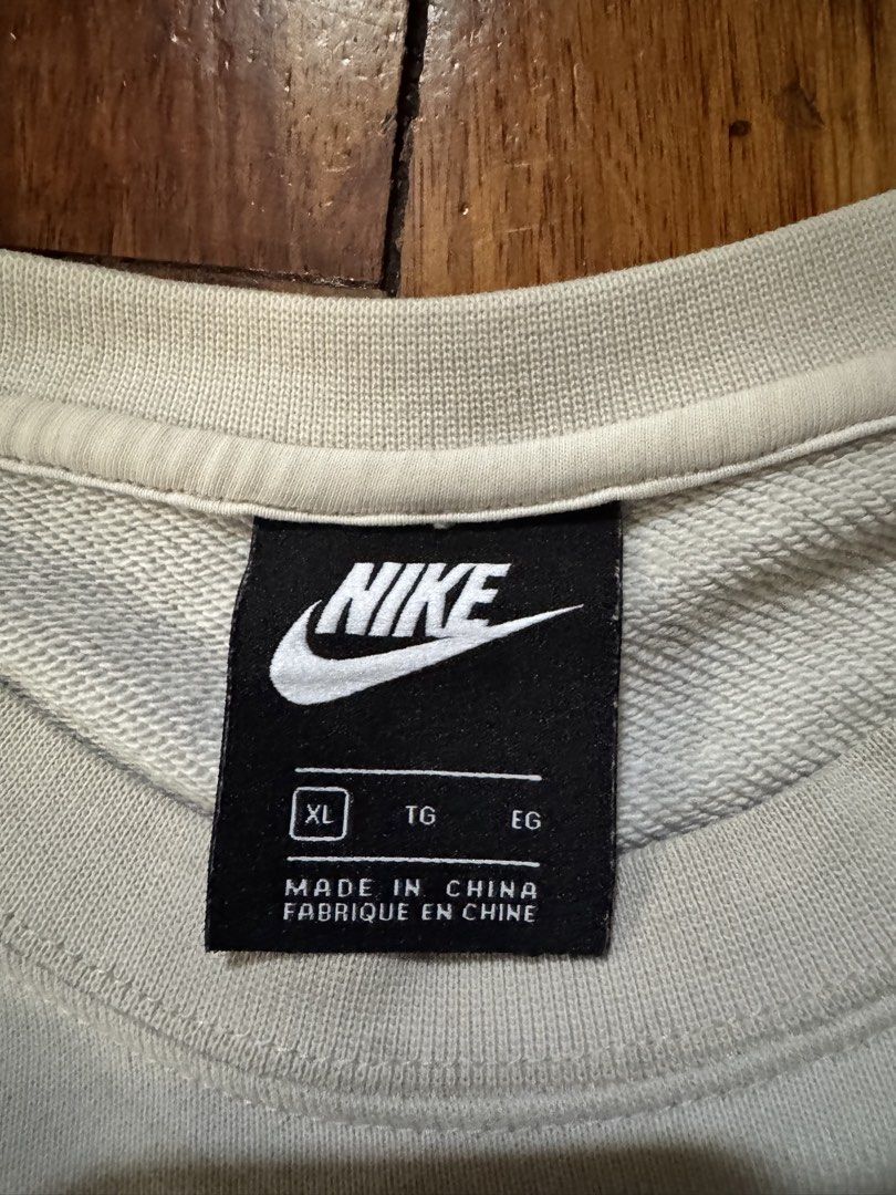 Nike Camo Logo White Sweatshirt (Category: Hoodies) located in Caloocan City. Submitted by gabbieerfritter (Listing ID 1465143177, Image 3). Description: - Brand: Nike - Style: Crewneck sweatshirt - Color: White with big camo graphic logo on the chest - Size: XL - Material: 80% cotton, 20% polyester blend (Made in China) - Condition: Normal wear with slight discoloration near the logo, still warm and comfortable.