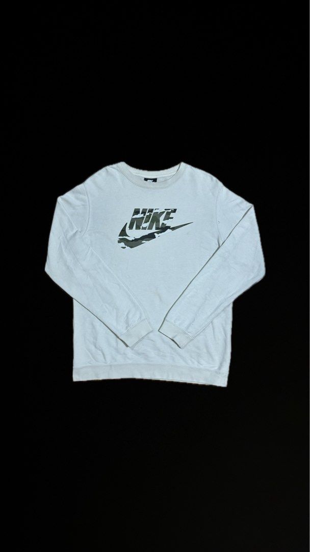 Nike Camo Logo White Sweatshirt (Category: Hoodies) located in Caloocan City. Submitted by gabbieerfritter (Listing ID 1465143177, Image 1). Description: - Brand: Nike - Style: Crewneck sweatshirt - Color: White with big camo graphic logo on the chest - Size: XL - Material: 80% cotton, 20% polyester blend (Made in China) - Condition: Normal wear with slight discoloration near the logo, still warm and comfortable.