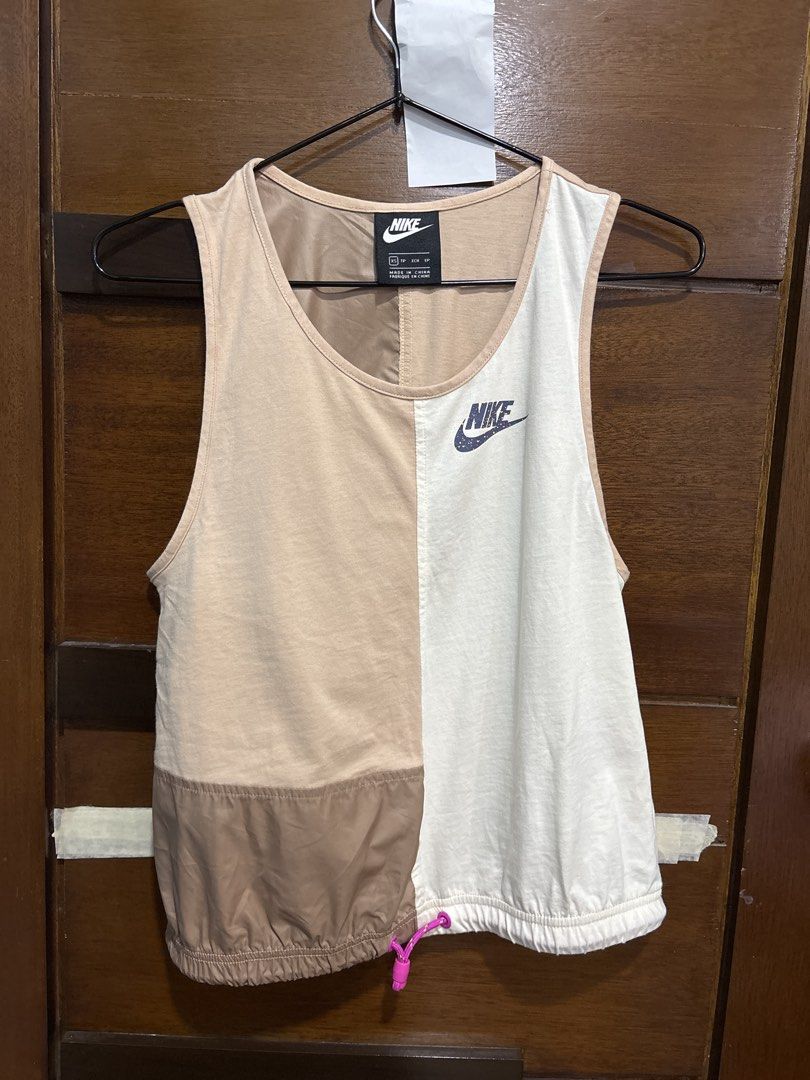 Nike Colorblock Tank Top XS (Category: Sleeveless) located in Mandaluyong City. Submitted by clothescarousel (Listing ID 1465072363, Image 1). Description: - Brand/Style: Nike colorblock tank top - Size: XS - Colorway: Beige, white, and brown with a bright pink drawstring toggle - Design: Split color front and back with printed Nike swoosh logo - Material: Lightweight cotton and nylon blend - Origin: Made in China.