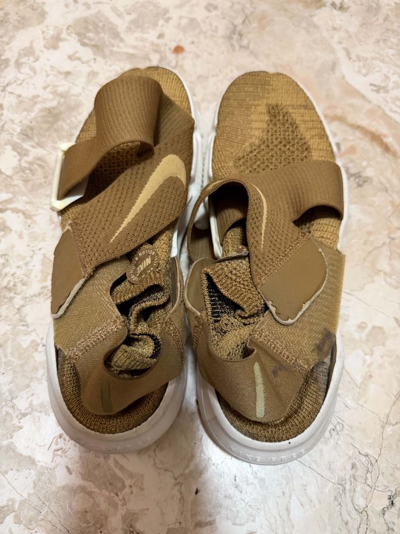 Nike Free Flyknit Sandal Gold (Category: Sneakers) located in Quezon City. Submitted by cms1116 (Listing ID 1465102080, Image 1). Description: - Brand: Nike - Model: Free Slip-On - Colorway: Gold with white Nike Free sole - Design: Unique cross-strap detail on top and heel - Material: Lightweight knit upper with flexible running-style sole - Condition: Wear and discoloration present throughout the fabric, with noticeable dark staining on the heel