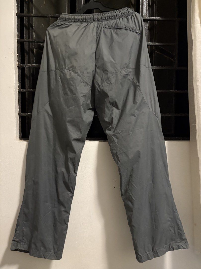 Nike Grey Nylon Track Pants Size L (Category: Joggers) located in Pakil. Submitted by lucii_4 (Listing ID 1465163431, Image 2). Description: - Brand: Nike - Item: Track Pants - Color: Grey - Size: Large (L) - Material: 100% nylon outer with polyester lining - Fit: Elastic waistband with adjustable drawstring - Pockets: Convenient zipper pocket on the back right side - Details: Small white Nike swoosh logo on front left thigh - Origin: Made in Vie