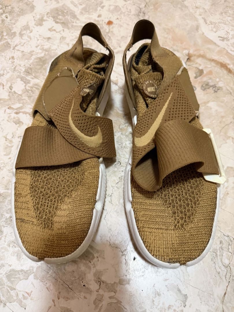 Nike Rift Wrap Gold Sneakers (Category: Sneakers) located in Quezon City. Submitted by cms1116 (Listing ID 1465102468, Image 1). Description: - Brand: Nike - Color: Gold with white sole - Style: Slip-on sneakers with elastic cross straps - Sole: Flexible white split-toe - Upper: Breathable knit construction - Features: Adjustable side buckle on the right shoe and supportive heel strap - Best for: Daily walking and casual outings - Condition: Grea