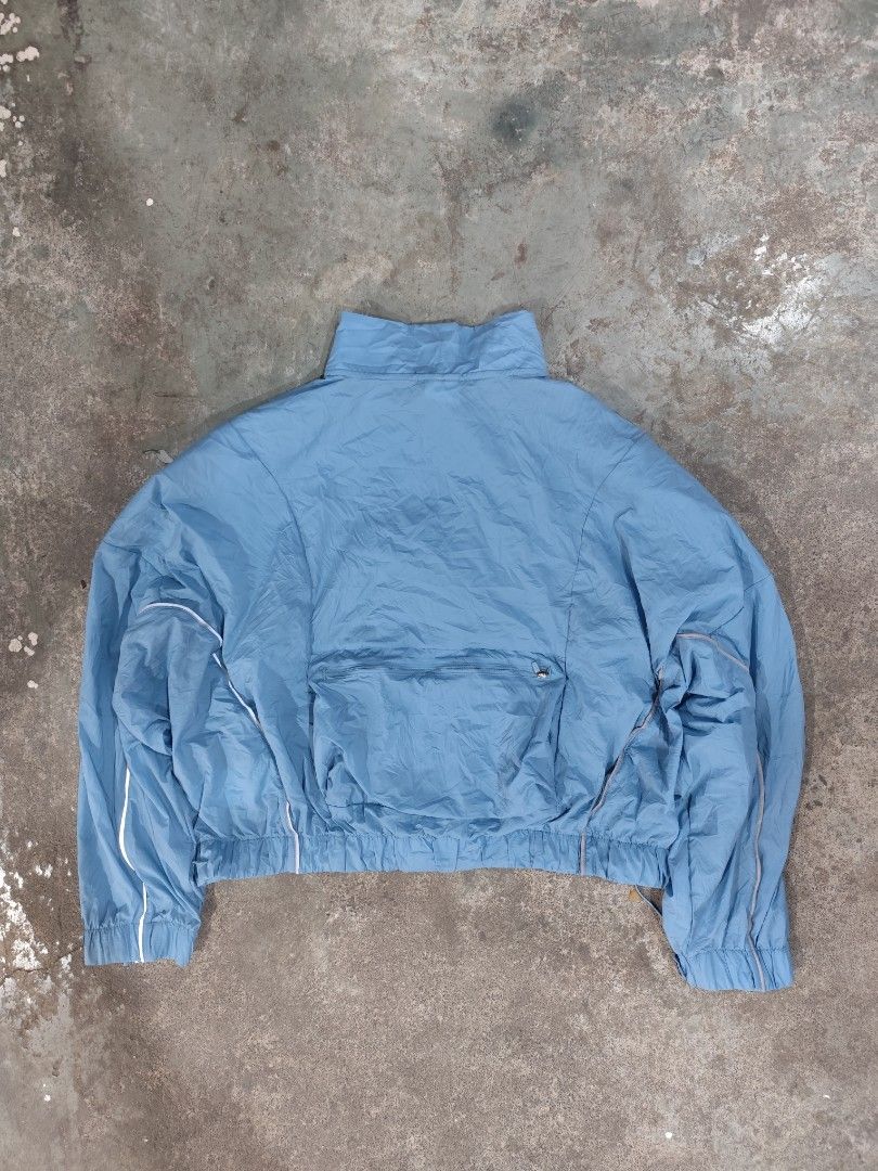Nike Running Division Packable Blue Windbreaker Jacket (Category: Coats, Jackets and Outerwear) located in Cordova. Submitted by bsb.streetluxvintage.clothing (Listing ID 1465072549, Image 2). Description: - Authentic Nike Running Division windbreaker in a sleek light blue color - Water-resistant and lightweight nylon fabric ideal for running - Packable design folds neatly into its own large back pocket - Reflective piping along the arms for bett