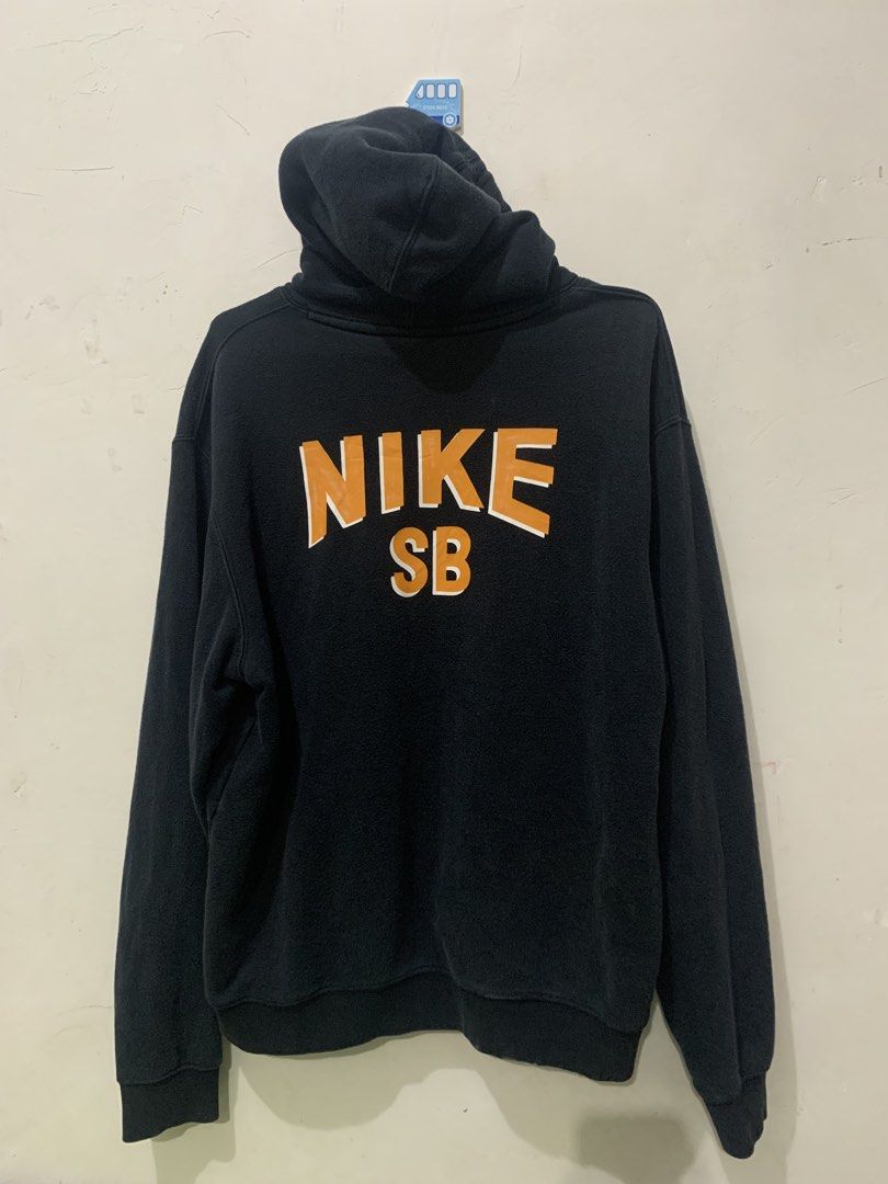 Nike SB Black Orange Hoodie (Category: Hoodies) located in Iligan City. Submitted by victhrift_shop (Listing ID 1464971699, Image 2). Description: - Brand: Nike SB - Color: Black with bright orange graphics - Design: Small chest logo and large curved text across the back - Features: Attached drawstring hood and front kangaroo pocket - Material: Comfortable cotton blend, ideal for everyday wear - Fit: Standard fit.